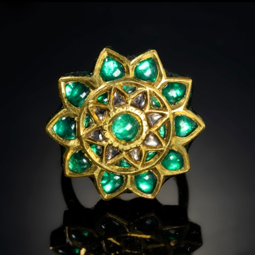 A 20th century Indian gold and enamel ring with foiled emeralds.